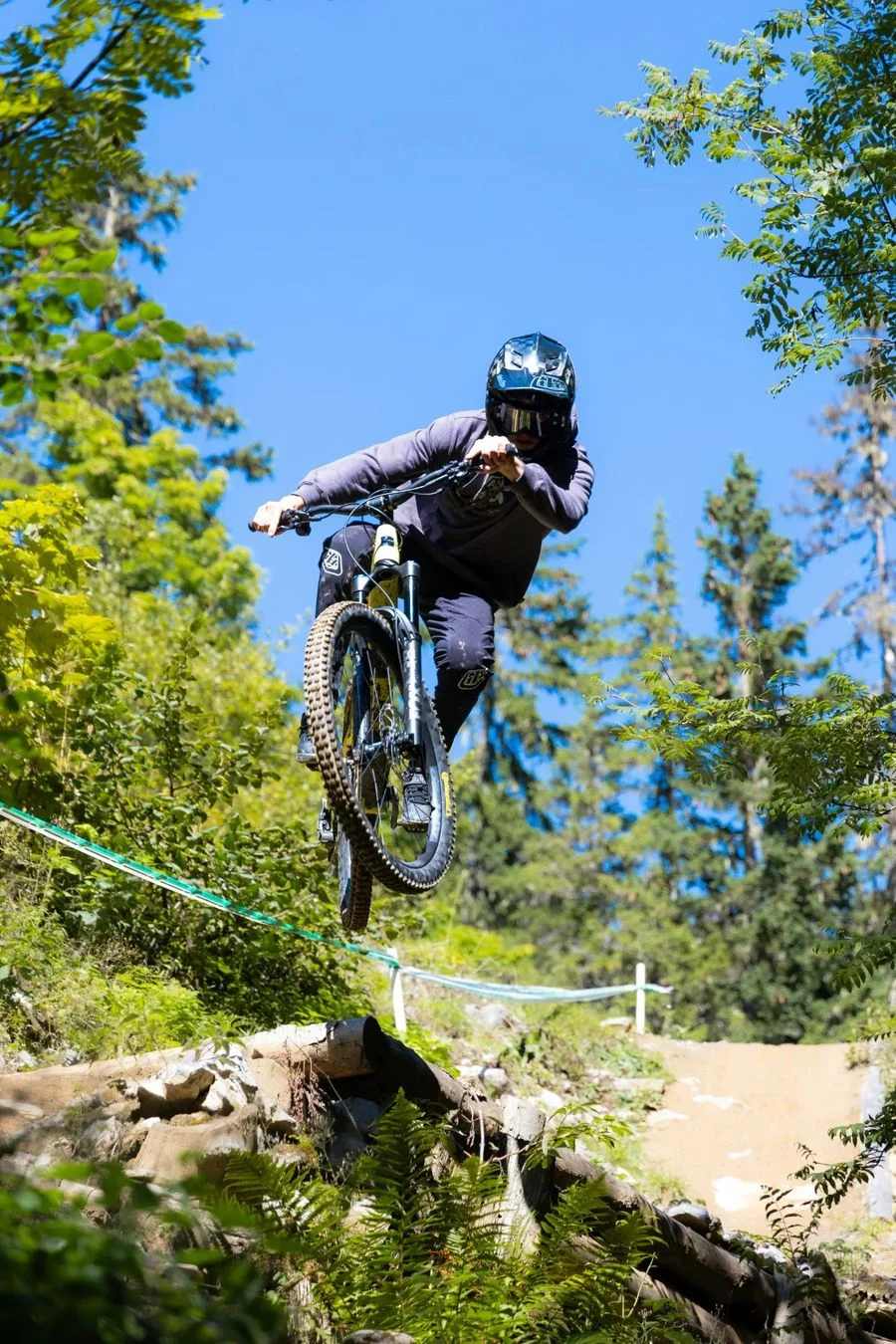 Un rider in mountain bike salta su un sentiero nel bosco